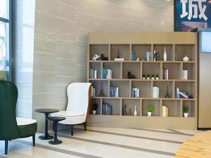 a room with a book shelf filled with books at City Comfort Inn Liupanshui Sports Center in Shuicheng