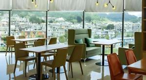 a restaurant with tables and chairs and a large window at City Comfort Inn Liupanshui Sports Center in Shuicheng