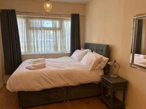 The HydeにあるBright 2BDR Home with Garden and Parking Wembleyの寝室にある白いシーツと枕が置かれたベッド