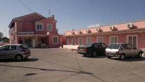 three cars parked in a parking lot in front of a building at Ambre Hotel in Lunel