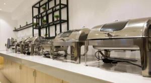 a row of stainless steel machines in a kitchen at City Comfort Inn Zhanjiang Middle Haibin Avenue Wanda Plaza in Zhanjiang +85 photos