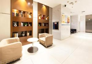 a lobby with two chairs and a table and shelves at City Comfort Inn Wuhan Zhongnan Road Metro Exit in Wuhan