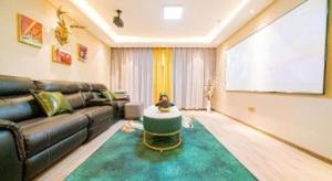 a living room with a leather couch and a large screen at Magnotel Tongxiang Shimao Center in Jiaxing