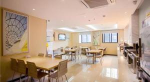 a restaurant with tables and chairs in a room at City Comfort Inn Yichang Dongshan Three Gorges University Shuiyuecheng in Yichang