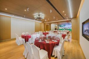 a banquet hall with white tables and white chairs at Deefly Yinrun Town Hotel in Deqing