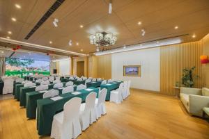 a banquet hall with green and white tables and chairs at Deefly Yinrun Town Hotel in Deqing
