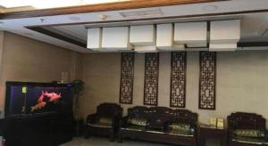 a room with three chairs and a tv on a wall at PAI Hotels Jinzhou Yi County Railway Station in Jinzhou