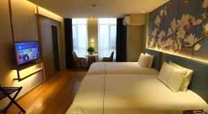 a hotel room with two beds and a television at Magnotel Hengshui Lake Jizhou Middle School in Hengshui