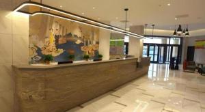 a lobby with a reception desk in a building at Magnotel Hengshui Lake Jizhou Middle School in Hengshui