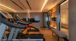 a room with a gym with several treadmills on a treadmill at Echarm Hotel Nanning Wuxiang Headquarters Base in Nanning