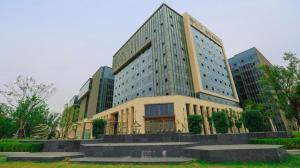 a large building with some stairs in front of it at Shell Hotel Nanyang High-Speed Railway Station Jiangying Airport Huayaocheng in Nanyang