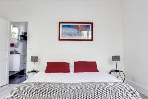 ein weißes Schlafzimmer mit einem großen weißen Bett mit roten Kissen in der Unterkunft Fontainebleau Sweet Home in Fontainebleau