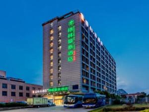 a building with a green sign on the side of it at GreenTree Inn Anqing Yingbin Dong Road High-Speed Railway Station in Anqing
