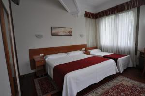 ein Hotelzimmer mit zwei Betten und einem Fenster in der Unterkunft Pension Alameda in San Sebastián