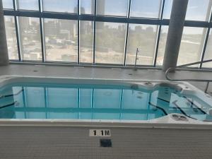 キッチナーにあるLuxury Condo with Hottub, outdoor firepit & Bowlinの大きな窓のある建物にある大きなプール
