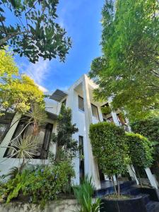 een wit huis met bomen ervoor bij Stay199 in Haragama