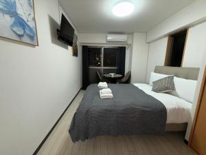 Ένα ή περισσότερα κρεβάτια σε δωμάτιο στο システムコ-ト戎本町