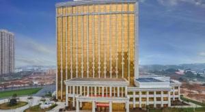 un grand bâtiment jaune avec beaucoup de fenêtres dans l'établissement Venus Royal Hotel Anhui Tongcheng Tongguoxiushui, à Wangguolu