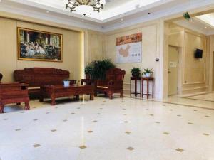 通遼市にあるVienna Hotel Inner Mongolia Tongliao Development Zoneの木製家具が備わる広い客室です。