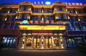 通遼市にあるVienna Hotel Inner Mongolia Tongliao Development Zoneの時計付きの建物