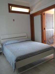スコペッロにあるPiccola Baiaのベッドルーム1室(ベッド1台付)、窓、ドアが備わります。
