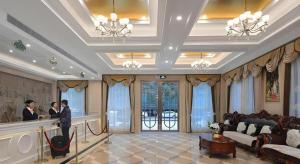 een lobby met twee mensen aan een balie bij Vienna Hotel Jiangsu Kunshan Qiandeng Town in Qiandun