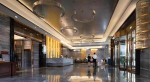 a lobby of a building with people standing in it at Venus Royal Hotel Nanning East High-Speed Railway Station in Nanning