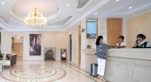 une femme se tenant au registre des espèces dans un hall d'hôtel dans l'établissement Vienna Hotel Anhui Huainan Shou County South Gate of Ancient Town Jinrun Central City, à Majiaxu