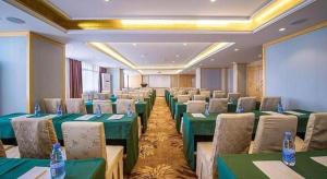 a conference room with green tables and chairs at Vienna Hotel Hubei Xiaogan Beijing Road in Xiaogan