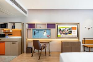 Una habitación con una cama y un televisor en la pared. en Home2 Suites by Hilton Zhangjiajie Tianmen Mountain, en Zhangjiajie