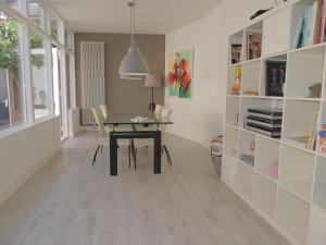 a dining room with a table and a book shelf at Sea & Dunes in Scheveningen