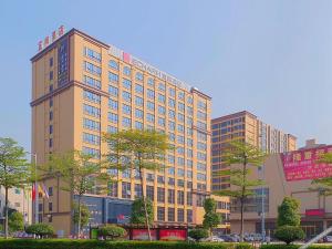 a large building with trees in front of it at Echarm Hotel Foshan West Station Shishan Luocun in Foshan