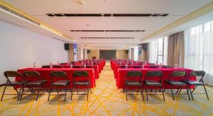 a conference room with red tables and chairs at Echarm Hotel Foshan West Station Shishan Luocun in Foshan