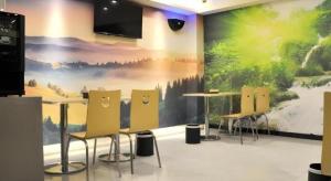 a room with tables and chairs and a large painting on the wall at Green Tree Inn Anhui Tianchang Economic Development Zone in Tianchang