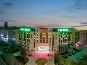a large building with a parking lot in front of it at Green Tree Inn Zhejiang Ningbo Yuyao Haijixincheng Wholesales Market in Ningbo