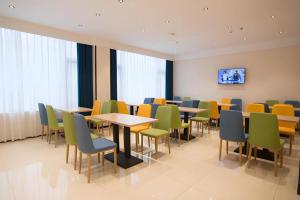 a waiting room with tables and chairs and a tv at City Comfort Inn Luzhou Jiangyang District Wancheng International in Luzhou