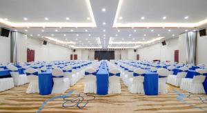 una grande sala banchetti con tavoli e sedie blu e bianchi di Echarm Plus Hotel Nanning Convention and Exhibition Center Medical University a Nanning