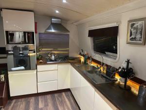 eine Küche mit Spüle und Mikrowelle in der Unterkunft The Royal Marina Escape! in Staines