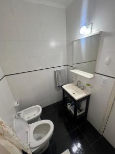 a bathroom with a toilet and a sink and a mirror at Check and Home - Peatonal II - 6 Huéspedes en el Centro a 3 cuadras de la Playa in Mar del Plata