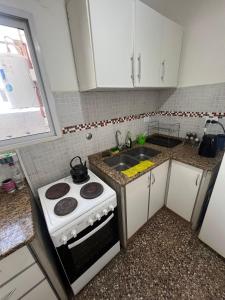 a kitchen with a stove and a sink at Check and Home - Peatonal II - 6 Huéspedes en el Centro a 3 cuadras de la Playa in Mar del Plata