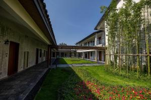 a courtyard of a building with flowers in the grass at Wuyuan Wunvzhou Wuxiandao Luxury Hotel in Wuyuan +23 photos