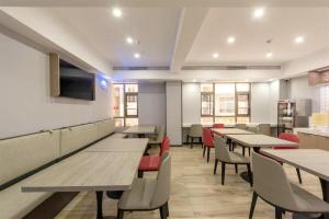 a dining room with wooden tables and chairs at Borrman Hotel Zhanjiang Jinshawan Chikan Republic of China Style Street in Zhanjiang