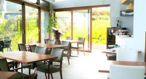 a restaurant with wooden tables and chairs and windows at Corredor Yugawara Dog＆Resort in Yugawara