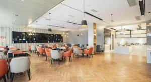 a dining room with tables and chairs in a restaurant at Echarm Hotel Leiyang in Leiyang
