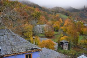 una casa vieja en una colina con árboles de otoño en El oso burlón, en La Viliella