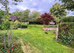 a garden with trees and flowers in a yard at Hempen Fied Gästehaus - Apartment 3 in Bad Zwischenahn +15 photos