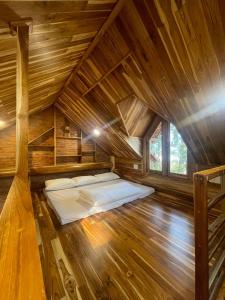 a bed in the middle of a wooden cabin at KND Wind Valley Bình Thuận in Xóm Chum Găng