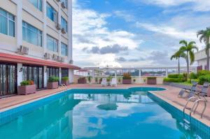 a swimming pool in front of a building with a hotel at Grand Szechuan Hotel Vientiane in Vientiane
