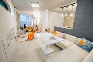 ein Wohnzimmer mit einer weißen Couch und einem Tisch in der Unterkunft Otter Stay - Takaoka in Aoichō