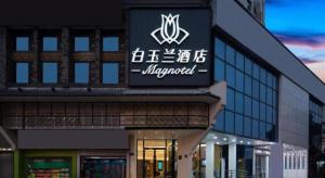 a building with a sign on the side of it at Magnotel Changsha Wuyi Square Metro Station National Finacial Center in Changsha
